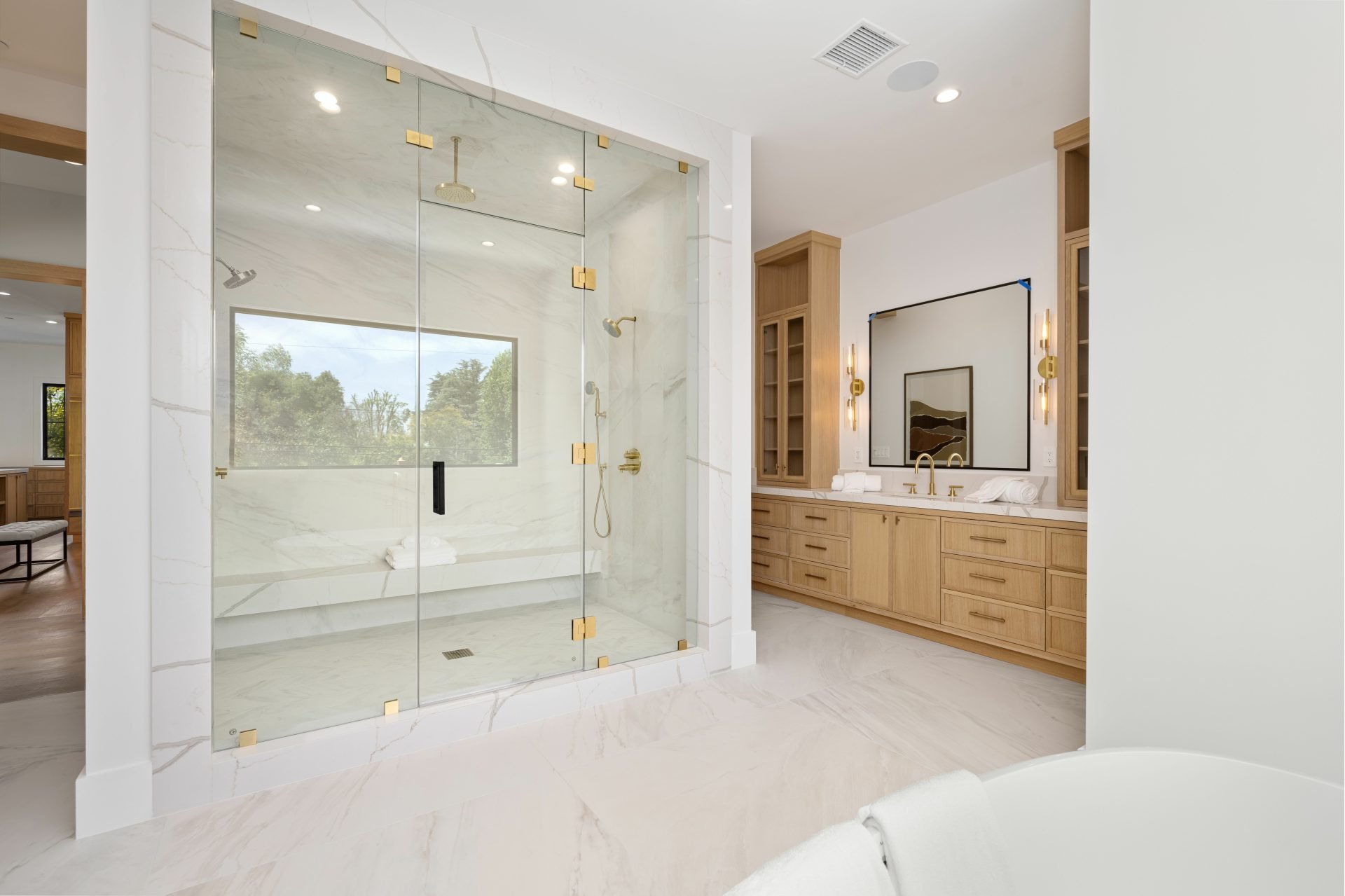 modern bathroom with glass shower and wooden cabinets.